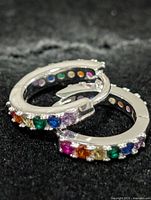 Front view of both silver hoops showing multicolour stones and clasp