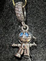 Front view of silver robot pendant showing blue stone helmet and pavé bail