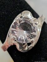 Top view of ring showing round faceted stone and prong swirl setting