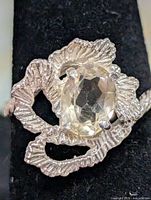 Front view of silver ring showing white topaz stone and textured setting