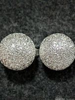 Frontal view of both silver ball stud earrings showing textured finish