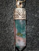 Front view of moss agate pencil pendant showing stone coloration and silver cap detail