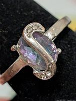 Front view of silver ring with mystic topaz and S-curve accent stones
