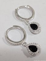 Front view of both silver hoop earrings with onyx and CZ drops