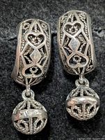 Front view of both earrings showing filigree hearts and lattice spheres