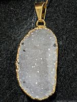 Front view of druzy quartz pendant showing crystalline surface and gold tone bezel
