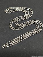 Full view of sterling silver figaro necklace laid out