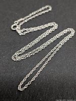 Full view of rope-style silver chain laid out