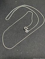 Full view of silver box chain laid flat showing length and overall appearance