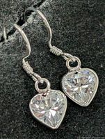 Front view of both earrings showing heart CZ stones and silver hooks