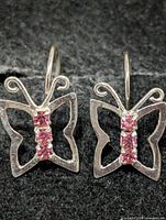 Front view of both butterfly earrings showing silver outline and pink stones