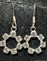 Front view of both earrings showing silver-tone finish and six-stone circular drop design