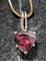 Front view of heart-cut garnet pendant showing gemstone color and prong setting