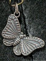 Front view of butterfly pendant showing detailed wing texture and bail
