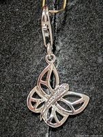 Full view of silver butterfly pendant showing design and clasp