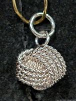 Front view of silver rope knot pendant showing design and jump ring