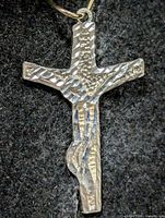 Front view of faceted silver cross pendant