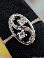 Front view of sterling silver ring showing oval bezel with S-shaped design and two stones