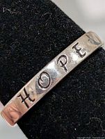 Close-up of HOPE engraving on silver ring