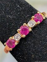 Front view of ring showing three rubies and two clear stones