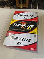 Three sealed boxes of Top-Flite XL Distance golf balls displayed stacked