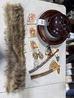 Table view showing all items: stoneware jug & bowl, faux fur, tiles, cloisonné pieces, glass pitcher, wooden models