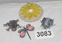 Front view of purse and three insect brooches