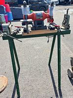 Full view of grinder on stand with vises and tools