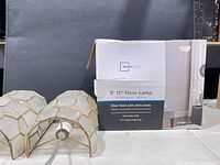 Boxed Mainstays floor lamp and two stained-glass shades visible