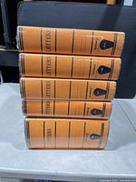 Stack of five sealed orange Amberg letter binders