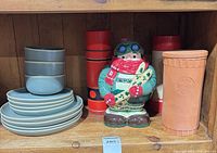 Overall lot showing stoneware plates and bowls, three thermoses, ceramic snowboarder cookie jar
