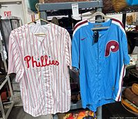 Front view of both Phillies jerseys on rack