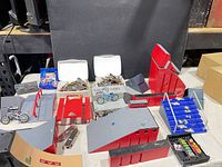 Overall view of assorted Tech Deck ramp pieces, fingerboards, bikes and cases on table
