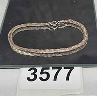 Full view of braided sterling silver bracelet on dark background