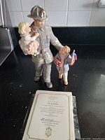Front view of Lenox firefighter figurine with two children