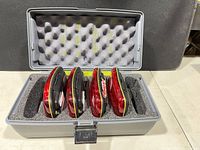 five red hazard lights seated in foam inside open gray case