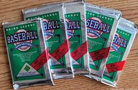 Five sealed 1990 Upper Deck Collector's Choice baseball card foil packs displayed on wooden surface