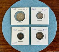 Group shot of four coins in 2×2 holders showing obverse sides and written dates