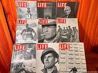 Seven Life magazines displayed on rack, all covers visible