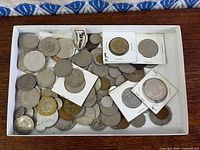 overview of box with mixed loose coins and flipped coins