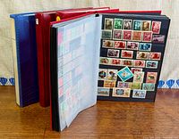 Four albums shown, one open displaying mounted Hungarian stamps