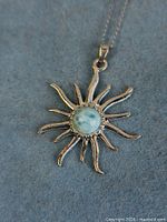 Front view of sterling sunburst pendant with larimar cabochon on chain