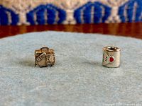 Front view of both Pandora charms on fabric background