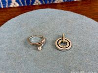 Ring and pendant side by side on fabric background