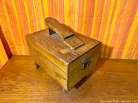 Three-quarter view showing oak shoe shine box, footrest handle, latch