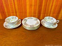 Full lot showing two cups with saucers and stacked side plates