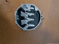 Front of round pendant showing silver silhouettes of four Beatles figures on black background