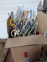 Cardboard box filled with assorted plastic hangers