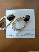 Front view showing teardrop design, rhinestones, black onyx, branding card