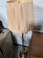 Full view of brass floor lamp with pleated shade